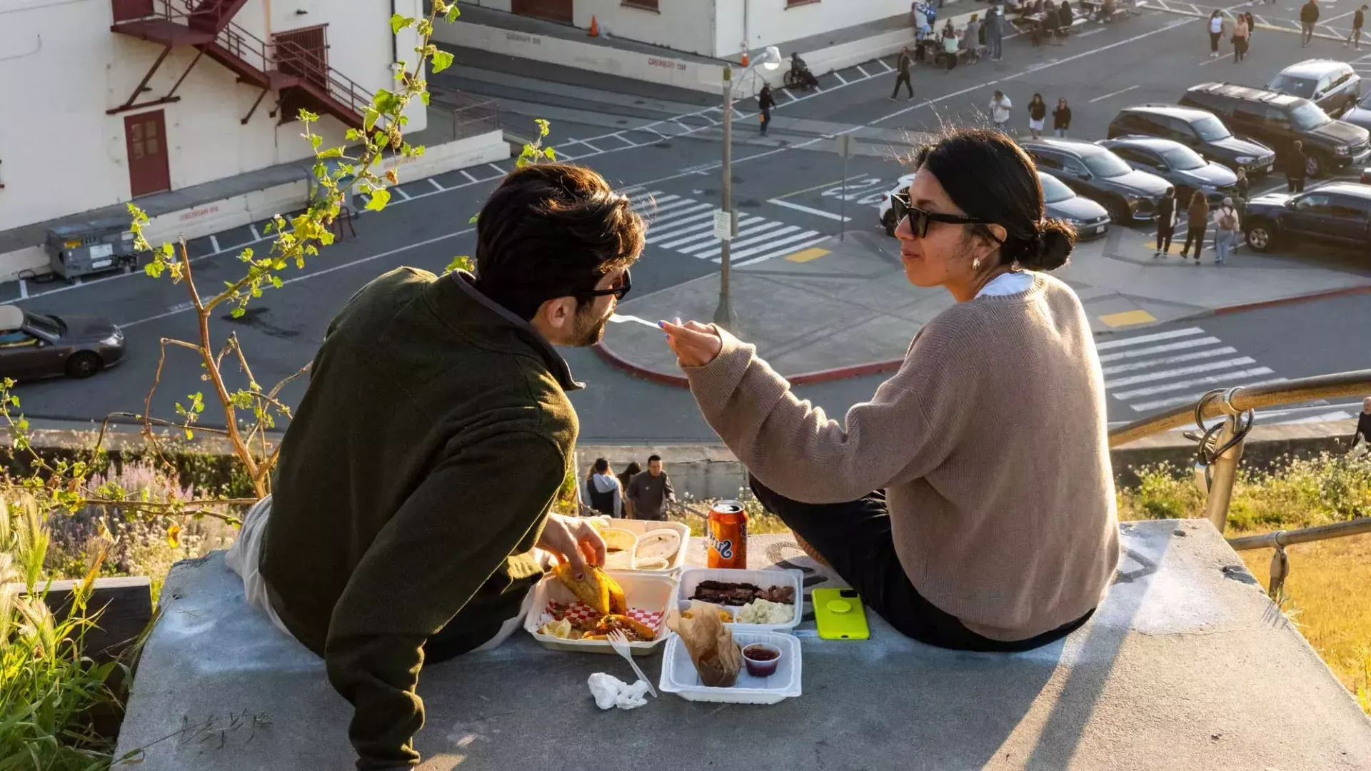 一对夫妇在贝博体彩app的梅森堡中心露天用餐. 那个女人让她的同伴尝了尝食物.