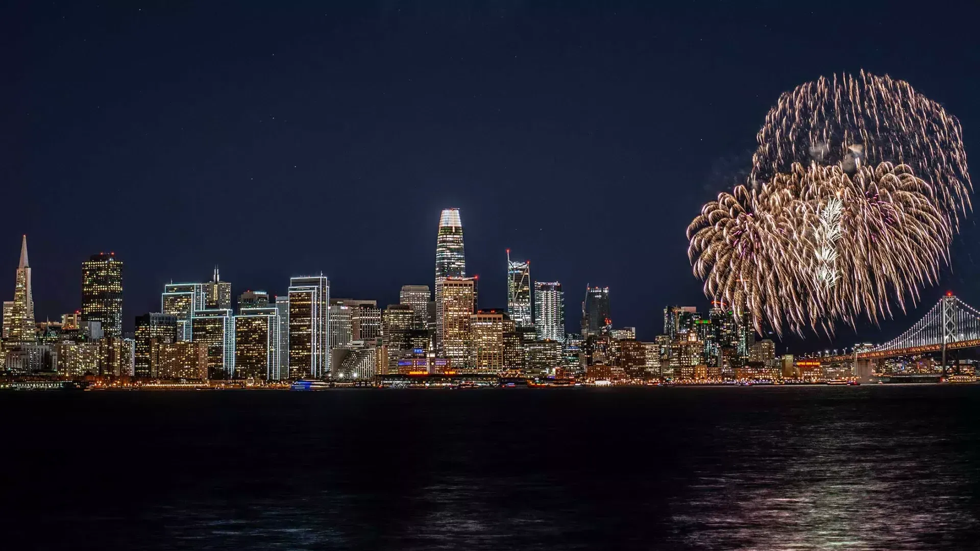 Über der Skyline von San Francisco explodiert ein Feuerwerk.