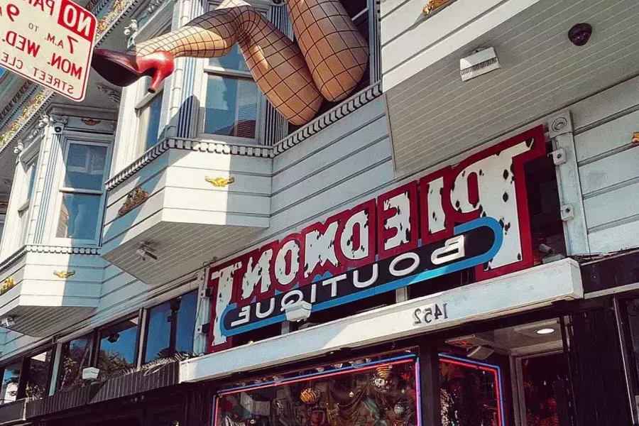 A pair of mannequin legs wearing fishnet stockings hang out of a window over Haight Street at Piedmont Boutique. 圣弗朗西斯科，加州.