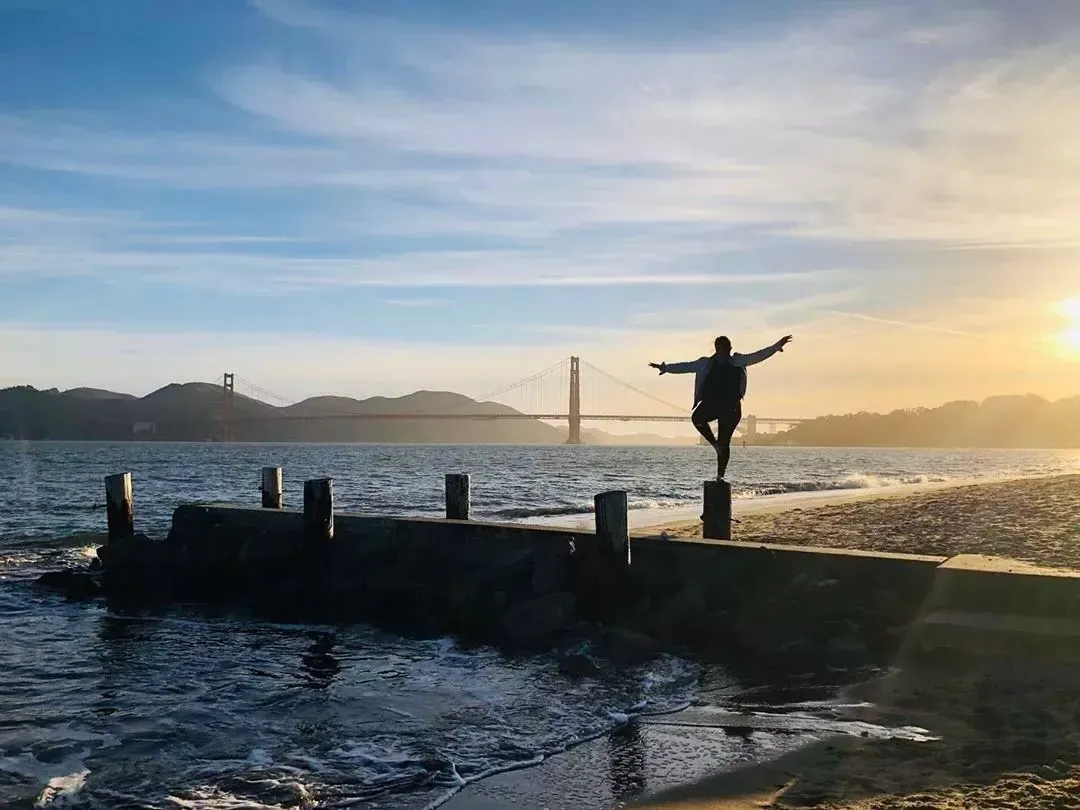 Eine Frau steht auf einem Pier im Stadtteil Marina in San Francisco und blickt auf die 金门大桥.